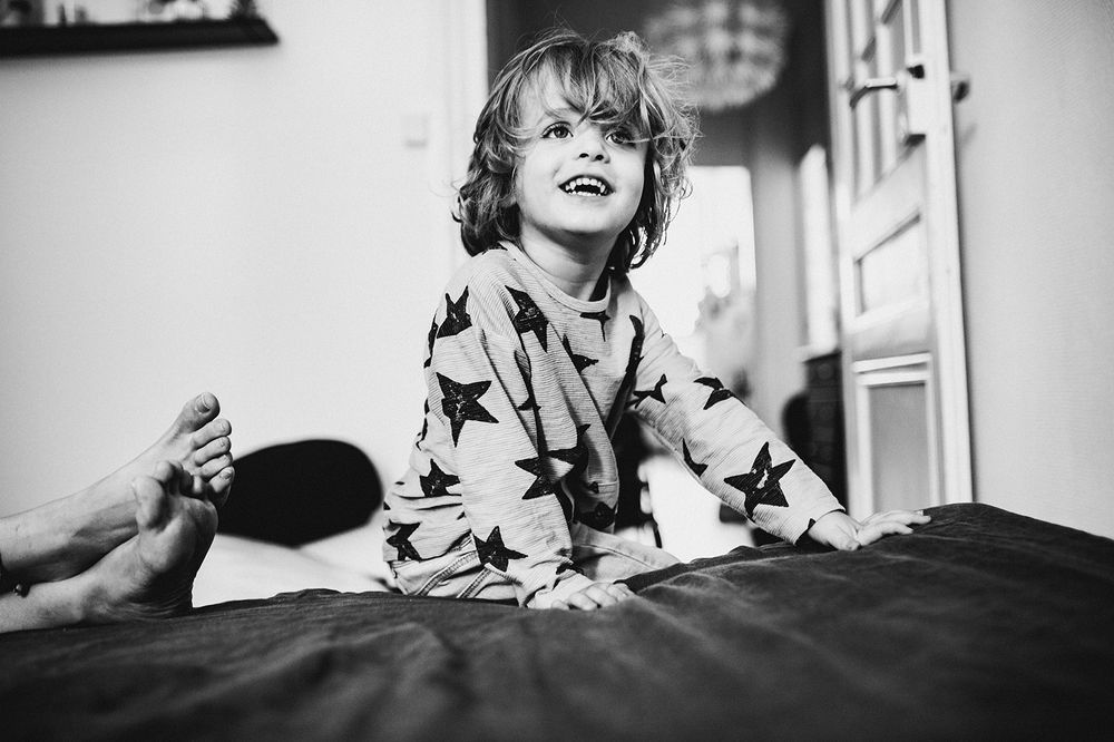 Grande sœur découvrant le nouveau-né avec émerveillement — séance famille ANtO photographe