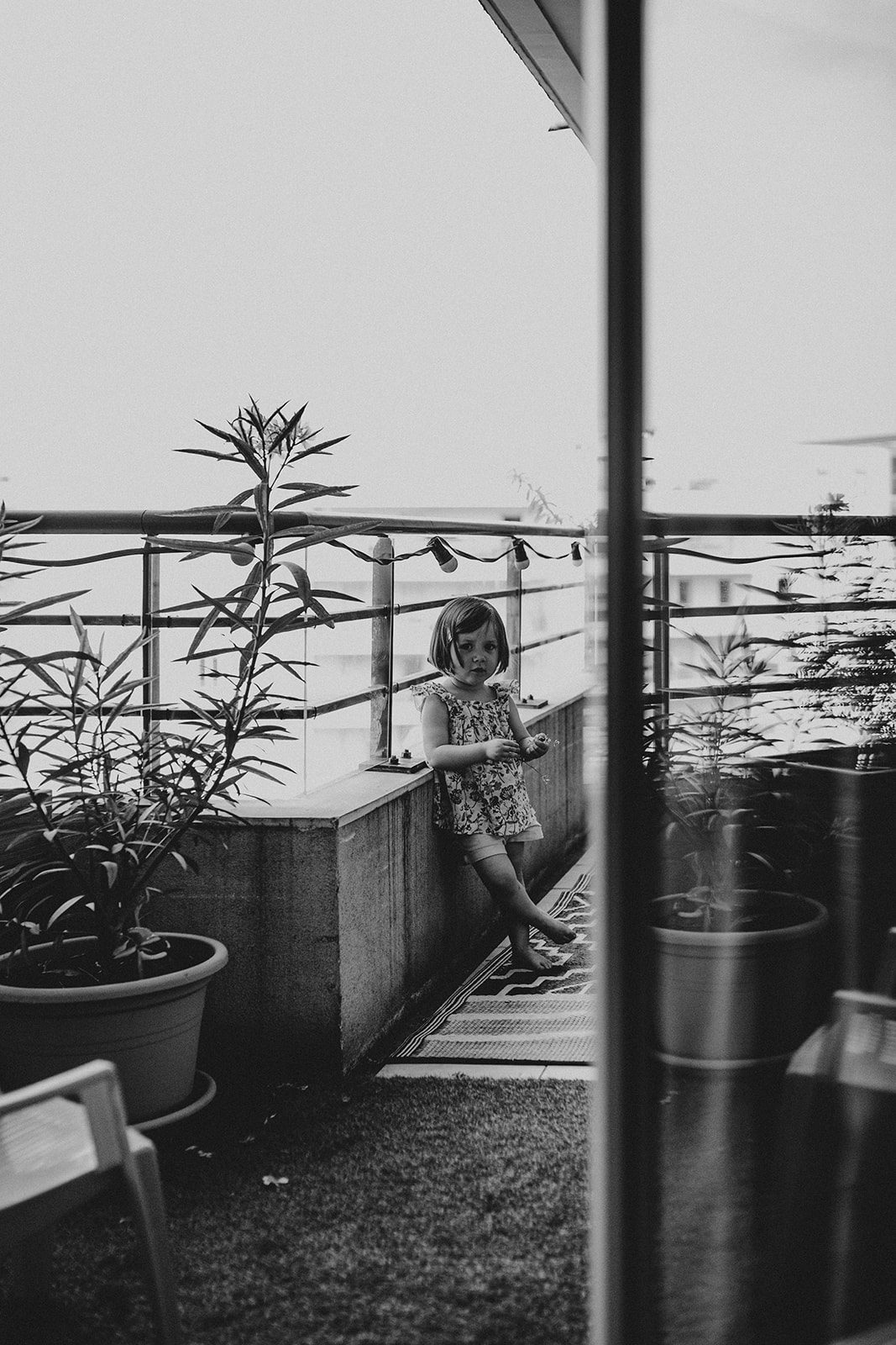 Petite fille pensive sur un balcon, portrait naturel — séance famille ANtO photographe