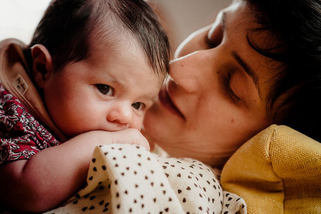 Jeune maman blottie contre son nouveau-né, regard tendre — séance naissance à Thiers, ANtO