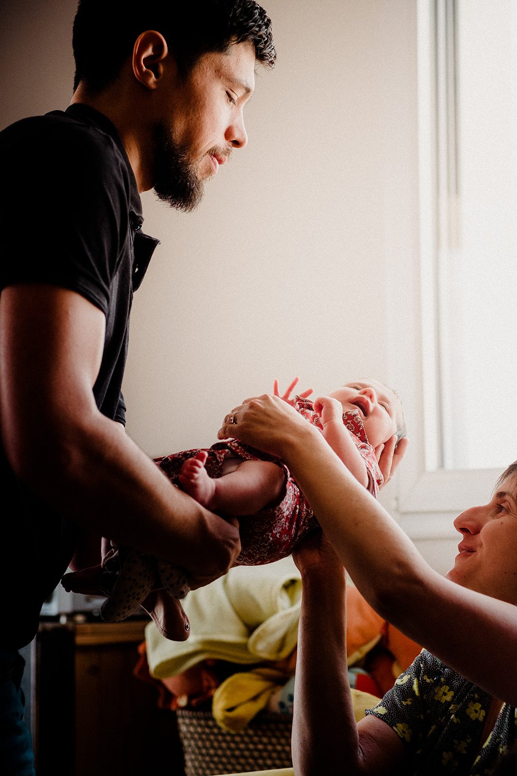 Père tenant son bébé à contre-jour, lumière dorée — séance famille ANtO photographe