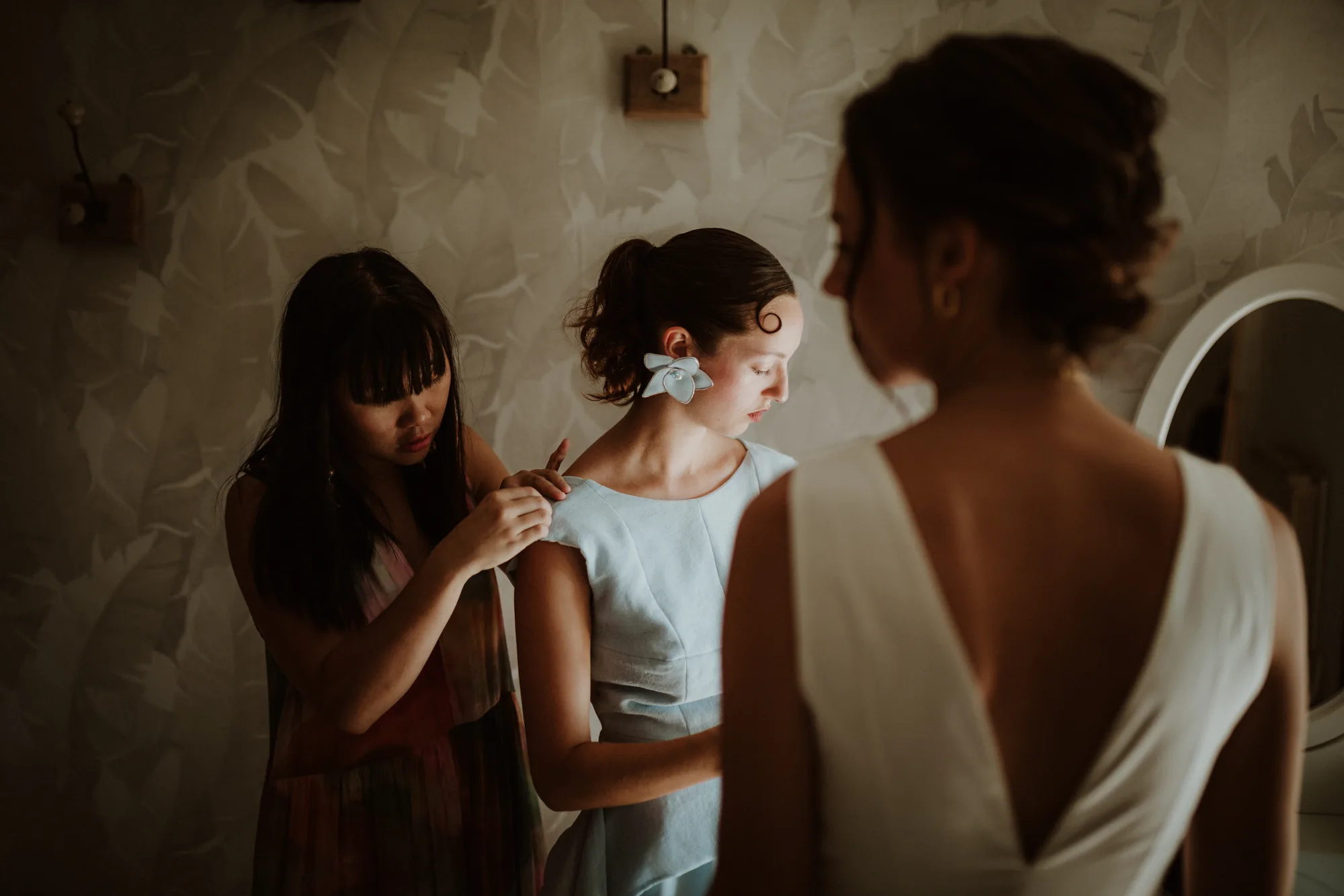 Une proche ajuste la robe de la mariée avant la cérémonie — mariage Thiers Clermont-Ferrand, ANtO photographe