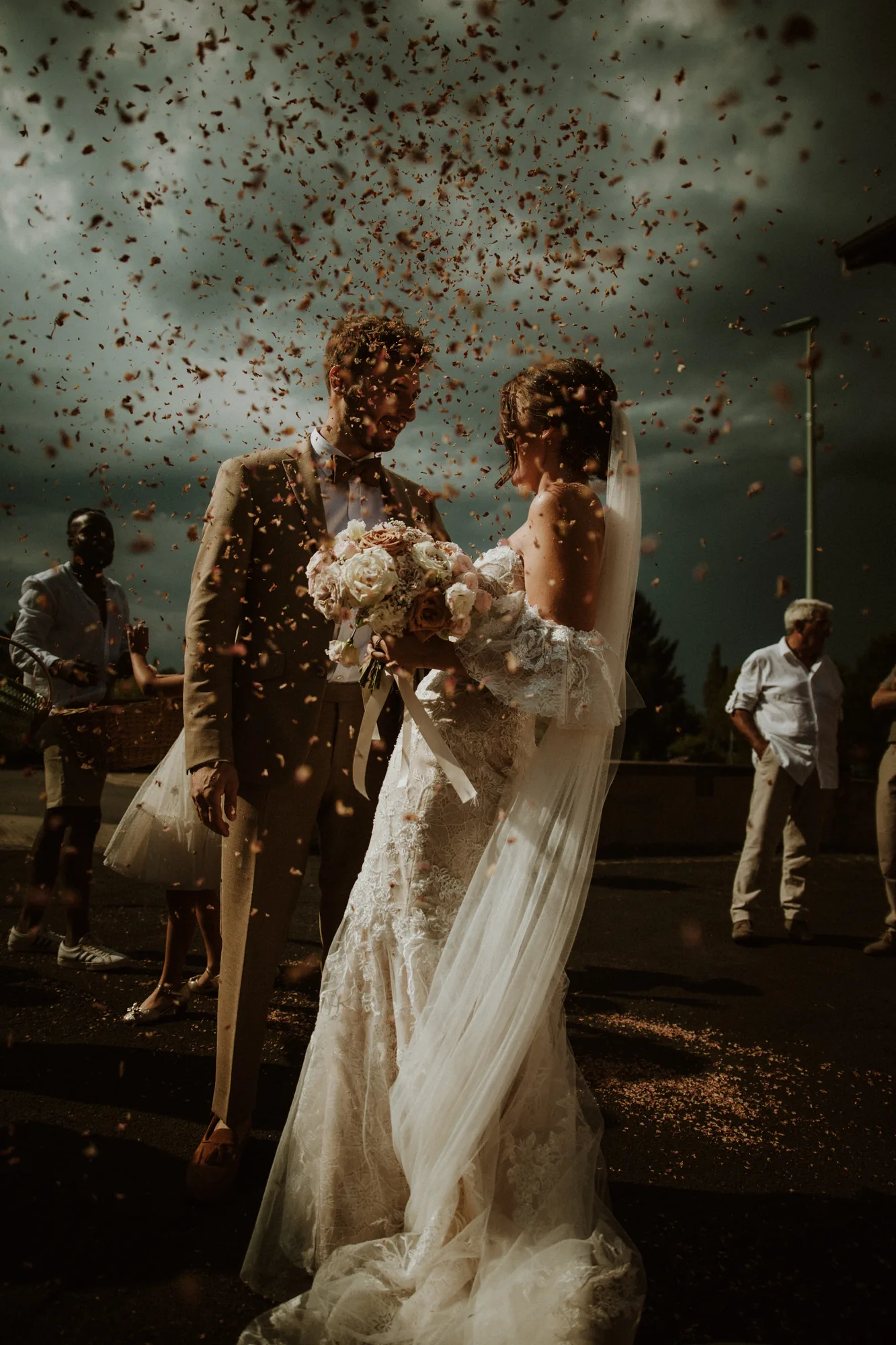 Mariés sous une pluie de confettis, ciel d'orage dramatique — mariage Thiers Clermont-Ferrand, ANtO photographe