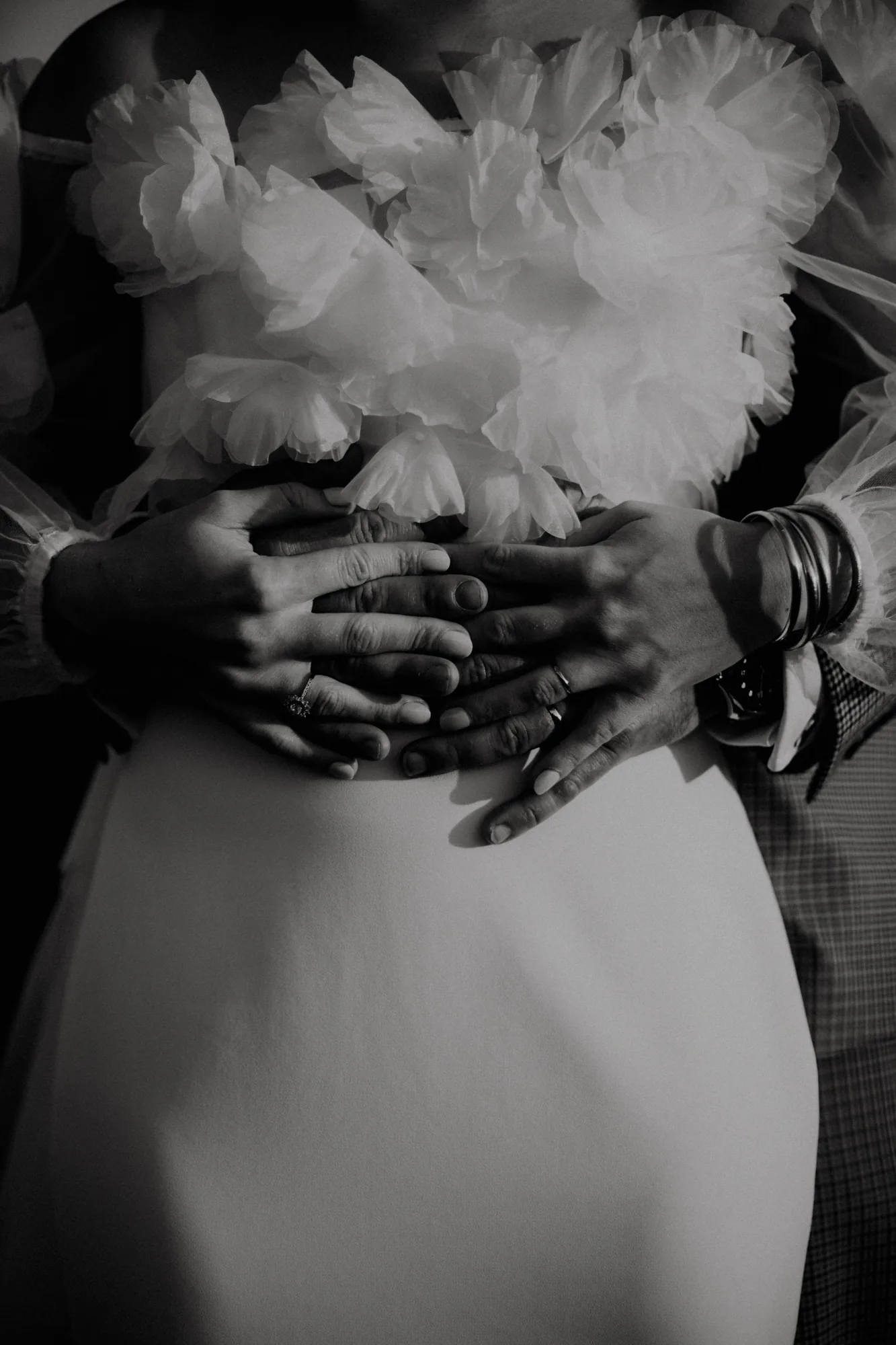 Mains des mariés enlacées sur la robe fleurie, détail intime — mariage Thiers Clermont-Ferrand, ANtO photographe