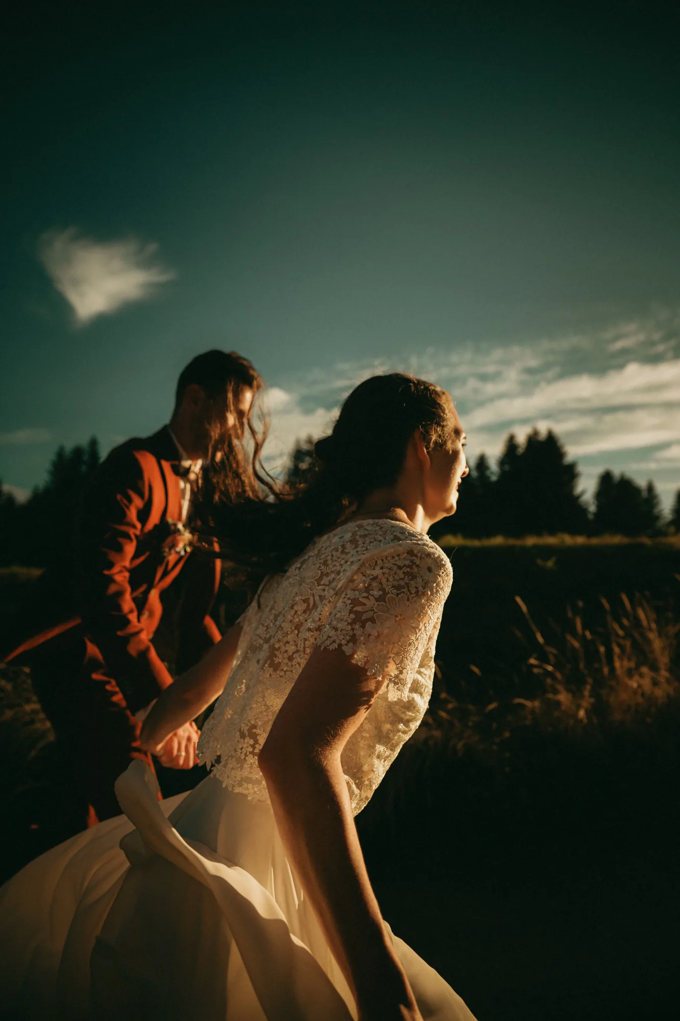 Mariés marchant main dans la main, ciel dramatique et vent dans la robe — mariage Thiers Clermont-Ferrand, ANtO photographe