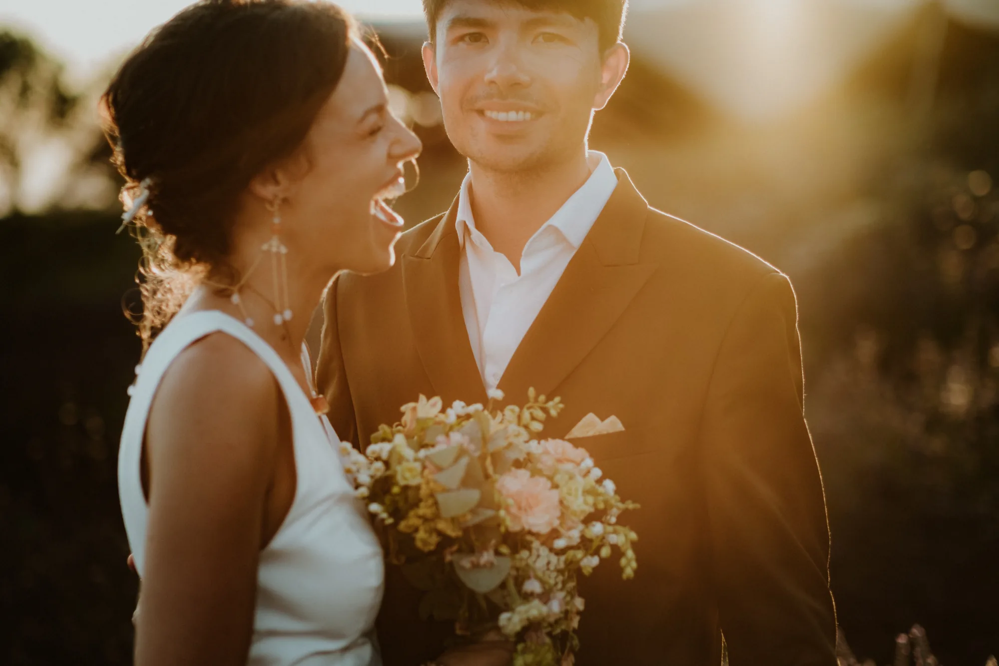 Mariés riant ensemble, bouquet à la main, lumière dorée — mariage Thiers Clermont-Ferrand, ANtO photographe