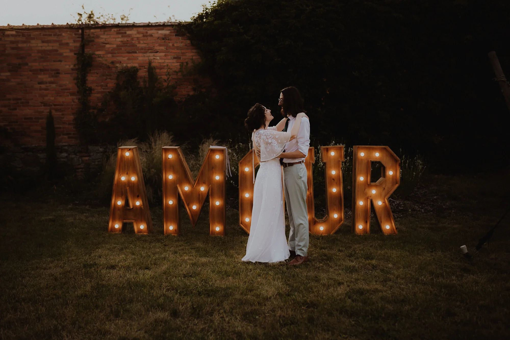 Les mariées devant les lettres lumineuses AMOUR